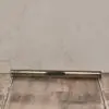A metal pipe sitting on top of a wooden floor.