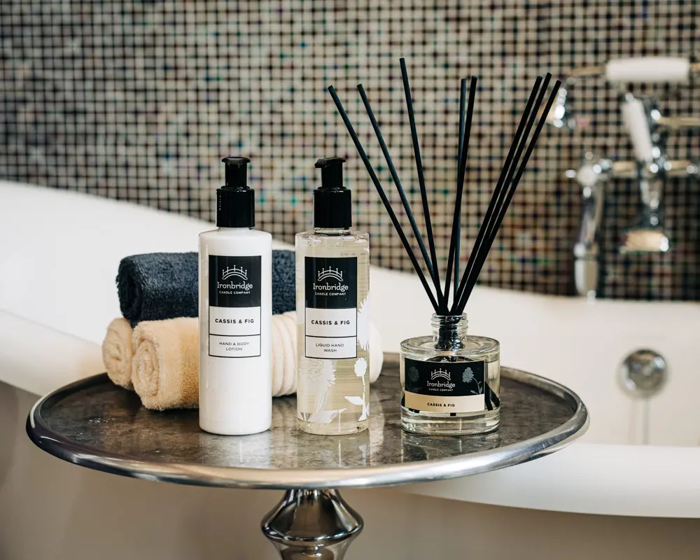 A tray with two bottles of lotion and a candle.