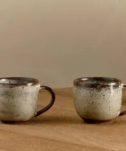 Cam Coffee Mug - Mocha Set of 2 by Nkuku, showing the paired 350ml ceramic mugs with individual glaze variations and rustic tableware style.