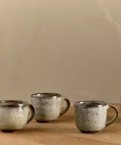Cam Coffee Mug - Mocha Set of 2 by Nkuku, showing two handcrafted ceramic mugs with a warm mocha colour and soft reactive glaze finish.