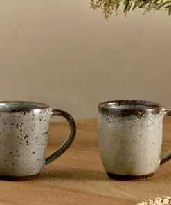 Cam Large Mug - Mocha Set of 2 by Nkuku, showing a matching pair of 350ml ceramic mugs with individual reactive glaze patterns and handcrafted character.