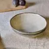 Malia Bowl - Cream by Nkuku, a 615ml cream stoneware bowl with a low rounded shape, soft reactive glaze and hand-painted line detail around the rim.