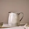 Malia Jug - Cream - Large by Nkuku, 1890ml cream stoneware jug with tall handled shape, curved pouring spout and hand-painted line detail.