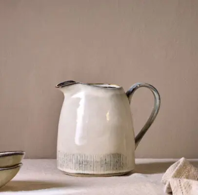Malia Jug - Cream - Large by Nkuku, 1890ml cream stoneware jug with tall handled shape, curved pouring spout and hand-painted line detail.