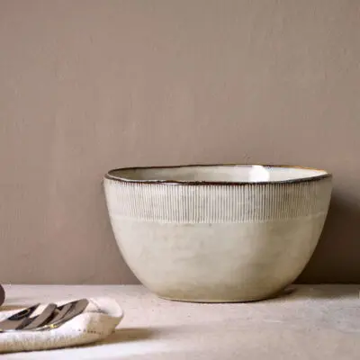 Malia Serving Bowl - Cream by Nkuku, a large 3100ml cream stoneware serving bowl with rounded shape, hand-painted rim detail and soft reactive glaze.
