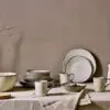Malia Jug - Cream - Small by Nkuku styled on a table, ideal for serving milk, cream, sauces or dressings with relaxed neutral tableware.