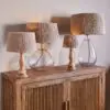Tiwa Woven Jute Lampshade by Nkuku styled on a lamp base, adding natural woven texture and soft diffused light to the room.