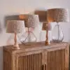 Tiwa Woven Jute Lampshade by Nkuku styled on a lamp base, adding natural woven texture and soft diffused light to the room.