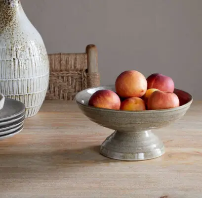 Valinha Earthenware Footed Bowl - Grey by Nkuku, showing the wide shallow bowl shape, raised footed base, textured spiral pattern and layered grey glaze.