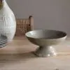 Valinha Earthenware Footed Bowl - Grey by Nkuku, showing the wide shallow bowl shape, raised footed base, textured spiral pattern and layered grey glaze.