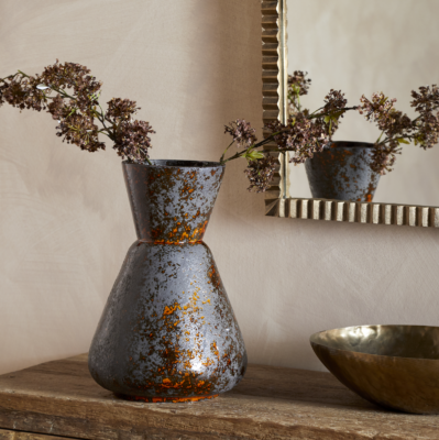 Brija Vase in Brown by Nkuku styled with flowers, featuring a rich reactive glaze and softly textured finish.