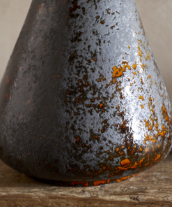 Brija Vase in Brown by Nkuku styled with flowers, closeup featuring a rich reactive glaze and softly textured finish.