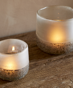 Riyara Recycled Glass Tealight Holder in Silver Sparkle by Nkuku styled and lit for a warm atmospheric effect.