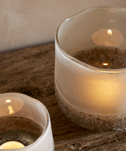 Close Up of Riyara Recycled Glass Tealight Holder in Silver Sparkle by Nkuku styled and lit for a warm atmospheric effect.