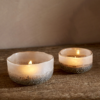 Riyara Recycled Glass Tealights in Silver Sparkle by Nkuku lit with candles, creating a soft warm glow through the textured glass.