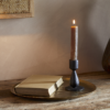 Suba Candle Holder in Black by Nkuku styled with a lit ester & erik cylindrical candle, creating a warm atmospheric glow.