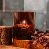 A candle sitting on top of a wooden holder.