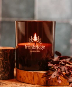 A candle sitting on top of a wooden holder.