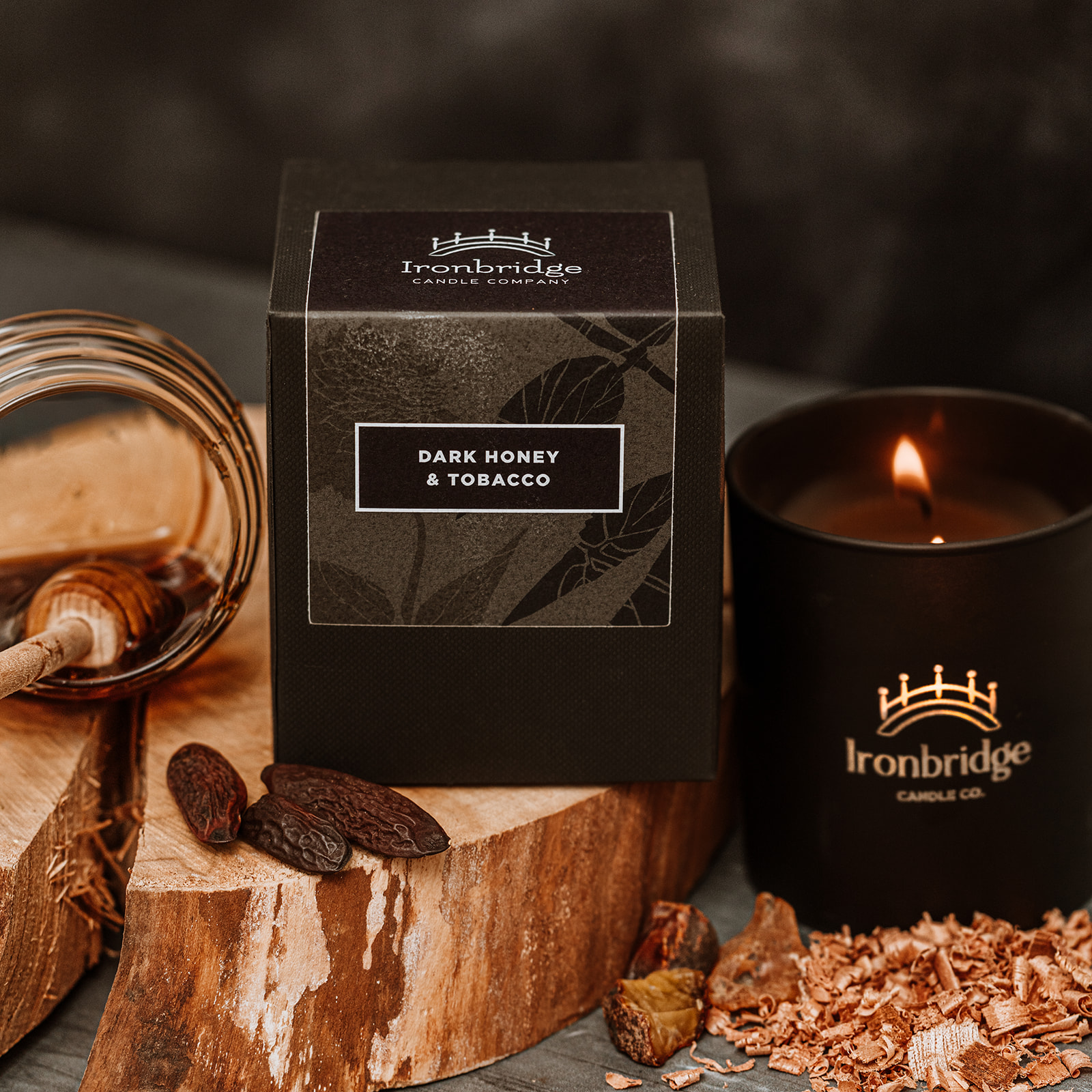 Lit Dark Honey & Tobacco luxury candle in black etched matt glass with warm smoky fragrance