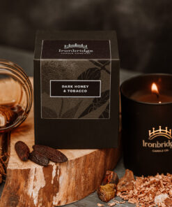 Lit Dark Honey & Tobacco luxury candle in black etched matt glass with warm smoky fragrance