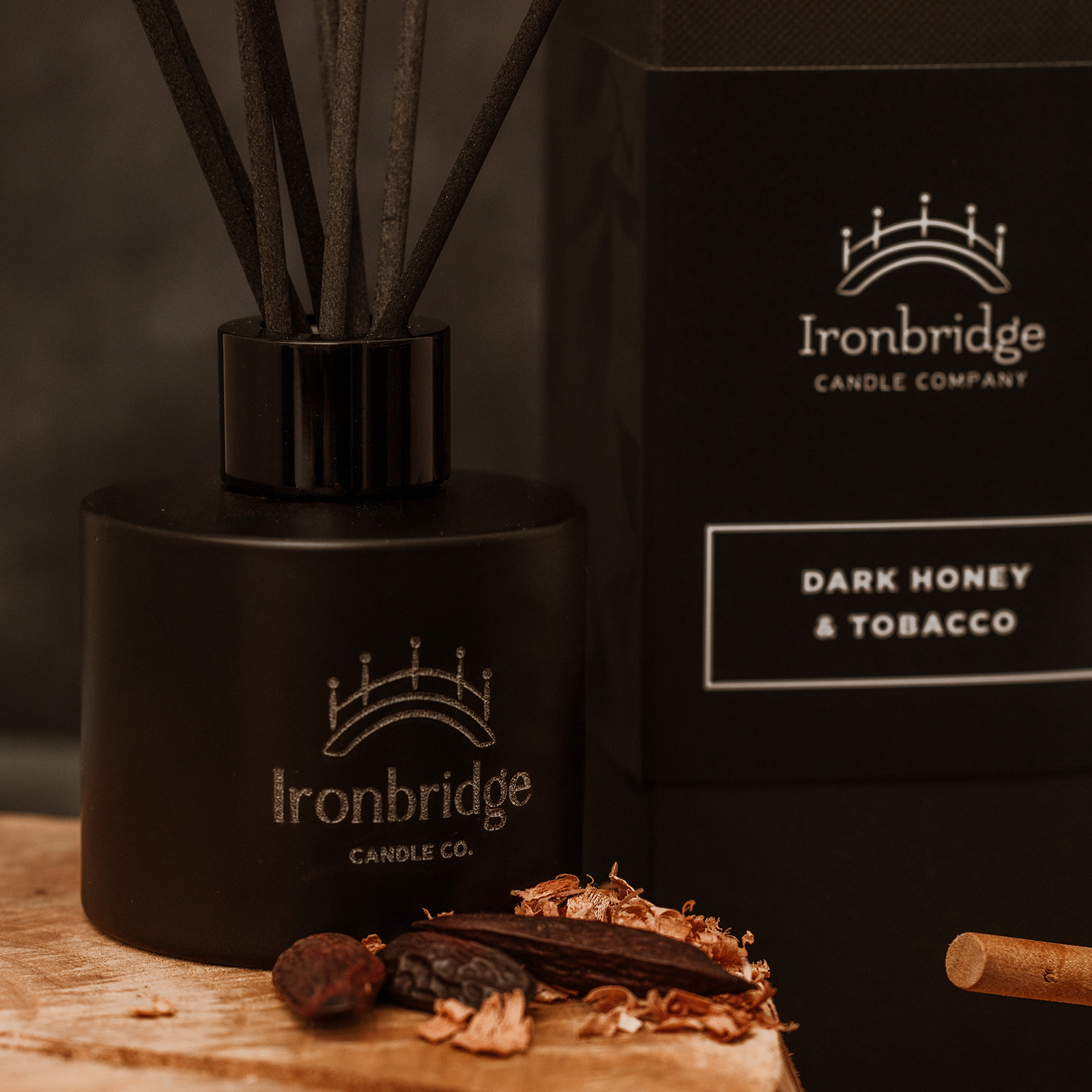 Close-up of Dark Honey & Tobacco reed diffuser in matt black etched bottle