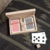 A wooden box with cards and dice on the floor.