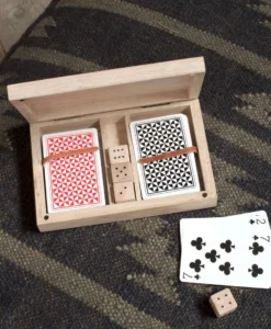 A wooden box with cards and dice on the floor.