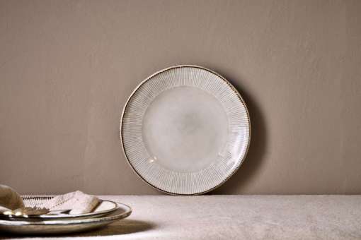 Malia Side Plate - Cream by Nkuku styled in a table setting, showing the 22.5cm plate size, neutral cream glaze and relaxed stoneware finish.
