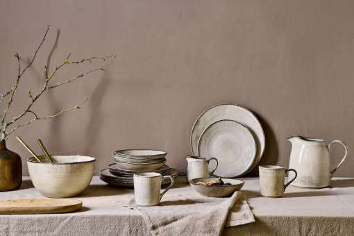 Malia Jug - Cream - Small by Nkuku styled on a table, ideal for serving milk, cream, sauces or dressings with relaxed neutral tableware.