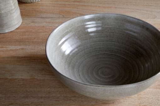 Close-up of the Valinha Earthenware Serving Bowl - Grey by Nkuku, showing the textured spiral pattern, grey earthenware surface and natural tonal variation in the glaze.