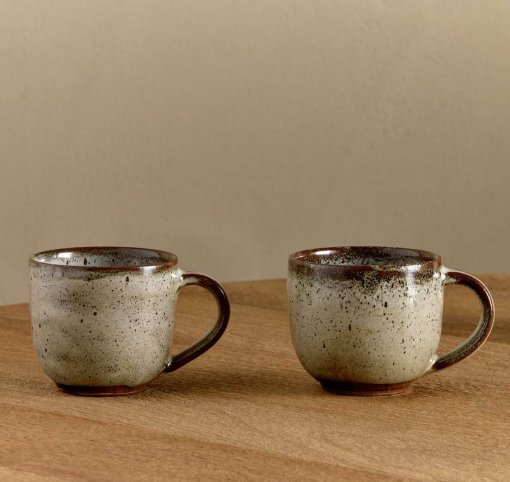 Cam Coffee Mug - Mocha Set of 2 by Nkuku, showing the paired 350ml ceramic mugs with individual glaze variations and rustic tableware style.