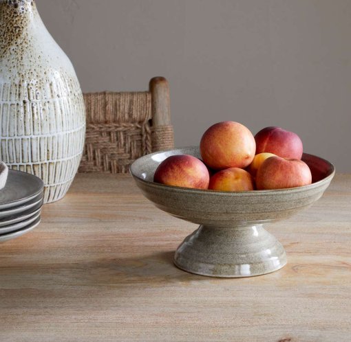 Valinha Earthenware Footed Bowl - Grey by Nkuku, showing the wide shallow bowl shape, raised footed base, textured spiral pattern and layered grey glaze.