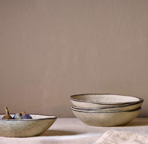 Malia Bowl - Cream by Nkuku styled in a table setting, showing the everyday bowl shape, neutral cream glaze and relaxed stoneware finish.