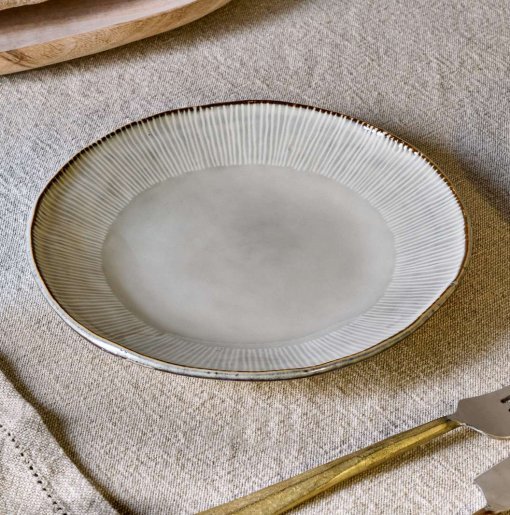 Malia Side Plate - Cream by Nkuku, a 22.5cm cream stoneware side plate with a shallow organic shape, soft reactive glaze and hand-painted rim detail.