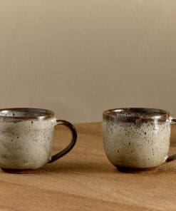 Cam Coffee Mug - Mocha Set of 2 by Nkuku, showing the paired 350ml ceramic mugs with individual glaze variations and rustic tableware style.