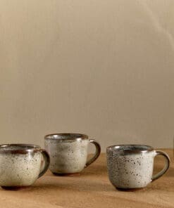 Cam Coffee Mug - Mocha Set of 2 by Nkuku, showing two handcrafted ceramic mugs with a warm mocha colour and soft reactive glaze finish.