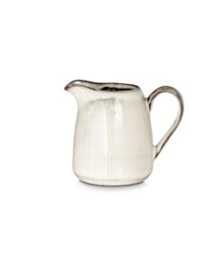 Close-up of the Malia Jug - Cream - Small by Nkuku, showing the cream glazed stoneware finish, subtle reactive variation and painted stripe detail.
