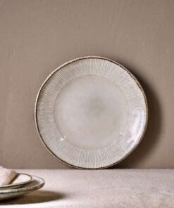 Malia Side Plate - Cream by Nkuku styled in a table setting, showing the 22.5cm plate size, neutral cream glaze and relaxed stoneware finish.