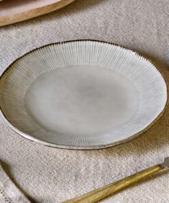 Malia Side Plate - Cream by Nkuku, a 22.5cm cream stoneware side plate with a shallow organic shape, soft reactive glaze and hand-painted rim detail.