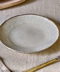 Malia Side Plate - Cream by Nkuku styled in a table setting, showing the 22.5cm plate size, neutral cream glaze and relaxed stoneware finish.