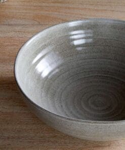 Close-up of the Valinha Earthenware Serving Bowl - Grey by Nkuku, showing the textured spiral pattern, grey earthenware surface and natural tonal variation in the glaze.