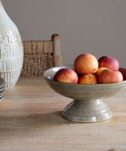 Valinha Earthenware Footed Bowl - Grey by Nkuku, showing the wide shallow bowl shape, raised footed base, textured spiral pattern and layered grey glaze.