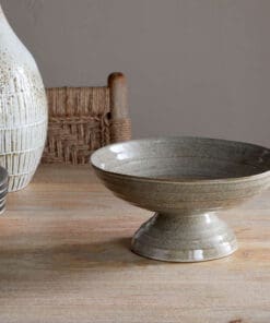Valinha Earthenware Footed Bowl - Grey by Nkuku, showing the wide shallow bowl shape, raised footed base, textured spiral pattern and layered grey glaze.