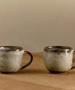 Cam Coffee Mug - Mocha Set of 2 by Nkuku, showing the paired 350ml ceramic mugs with individual glaze variations and rustic tableware style.