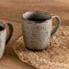 Cam Large Mug - Mocha Set of 2 by Nkuku, showing two large ceramic mugs with warm mocha colouring, a soft mottled reactive glaze and rustic handmade-style finish.