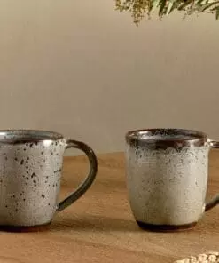 Cam Large Mug - Mocha Set of 2 by Nkuku, showing a matching pair of 350ml ceramic mugs with individual reactive glaze patterns and handcrafted character.