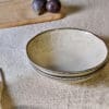 Malia Bowl - Cream by Nkuku styled in a table setting, showing the everyday bowl shape, neutral cream glaze and relaxed stoneware finish.