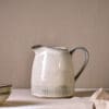 Malia Jug - Cream - Large by Nkuku, 1890ml cream stoneware jug with tall handled shape, curved pouring spout and hand-painted line detail.
