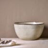 Malia Serving Bowl - Cream by Nkuku, a large 3100ml cream stoneware serving bowl with rounded shape, hand-painted rim detail and soft reactive glaze.