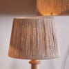 Tiwa Woven Jute Lampshade by Nkuku in natural jute, with loose woven fibres, neutral colour and a relaxed rustic texture.